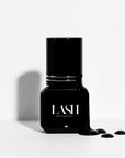 Black nail polish bottle with 'LASH' branding on a white background